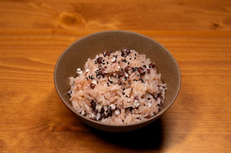 A bowl of multigrain rice with visible beans and black sesame seeds
