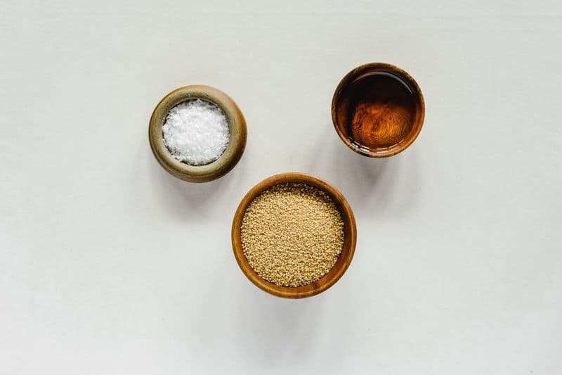 Bowls of sesame seeds, salt, and dark toasted sesame oil viewed from above