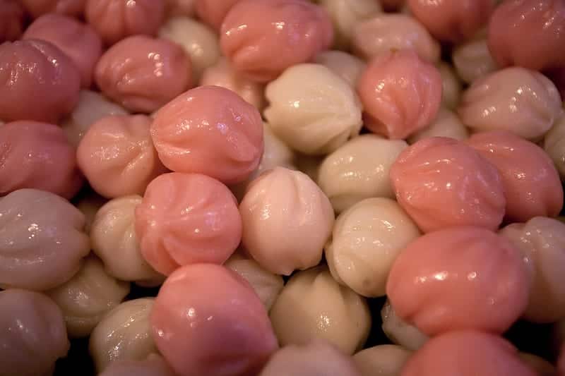 Pink and white pinched half-moon rice cakes stacked together