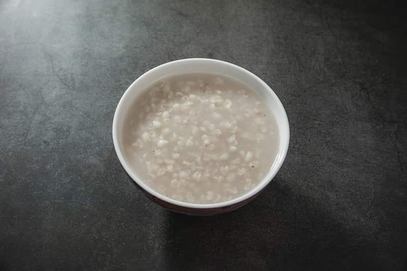 A bowl of pale toasted rice water with soft rice grains
