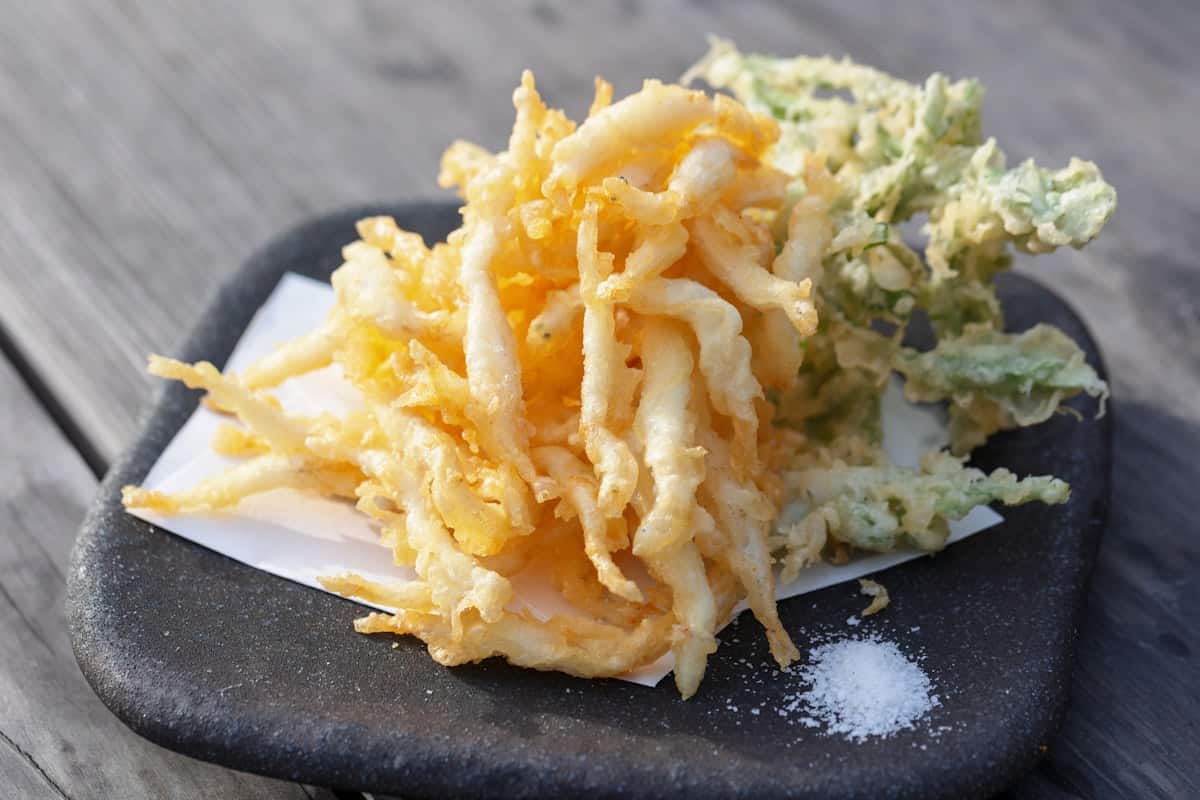 Assorted golden fried vegetable and seafood fritters on a plate