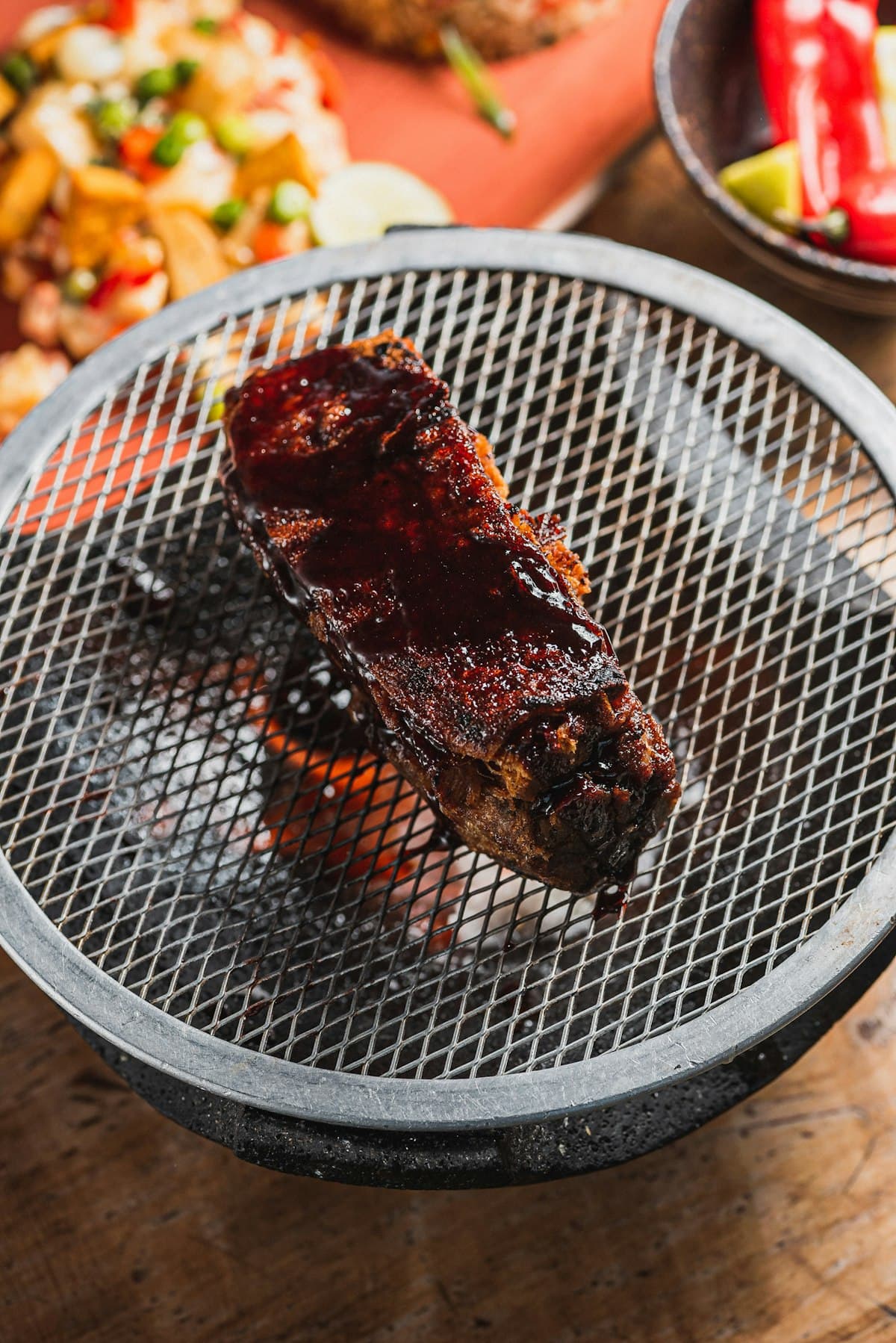 Marinated short ribs grilling over hot coals with glossy glaze