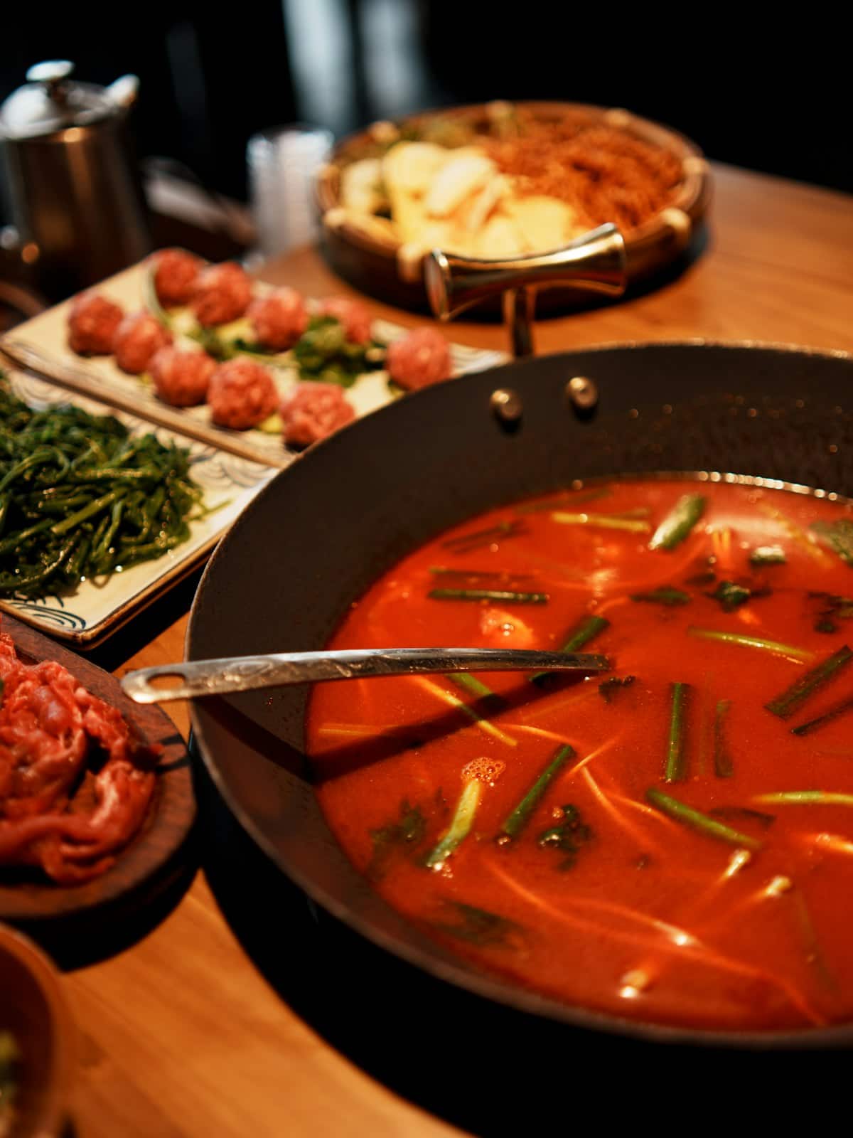 Spicy red Korean beef soup with shredded meat and vegetables in a pan