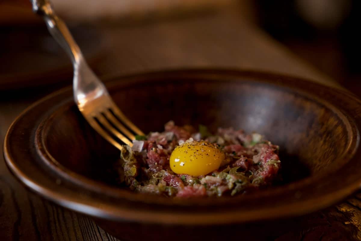 Thin strips of raw beef seasoned and topped with a raw egg yolk